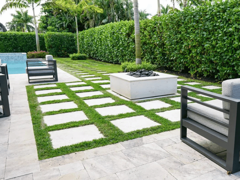 Neatly grass lined pool pavement Pool landscaping in Naples by Executive Lawn Services