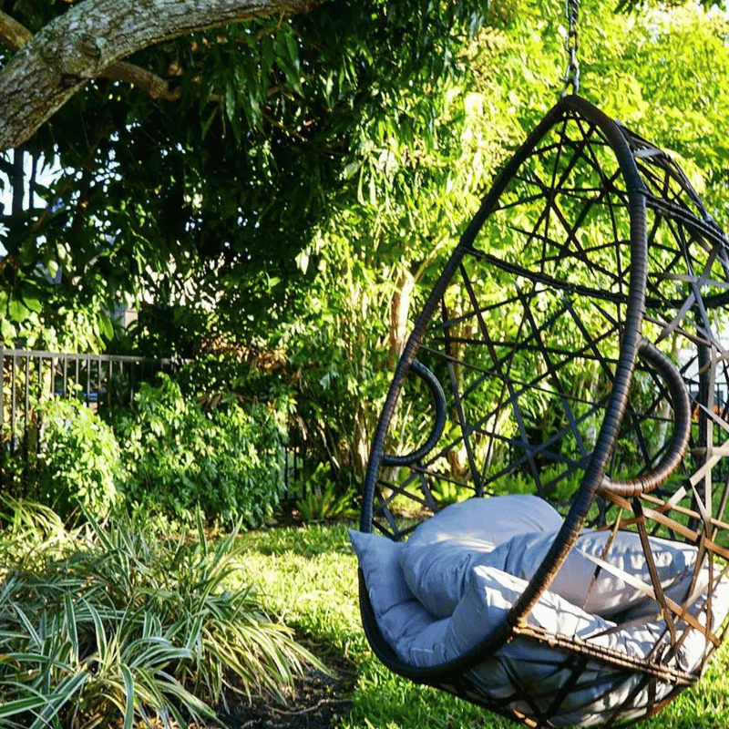 Swinging chair in a garden Creating outdoor sanctuaries in Naples by Executive Lawn Care